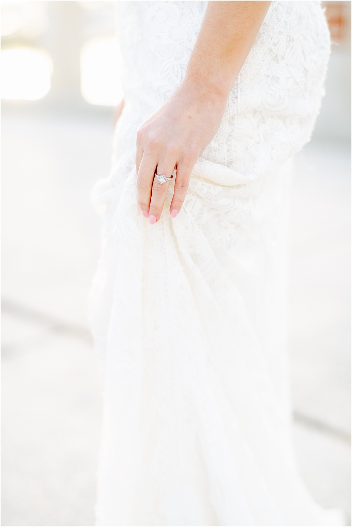 elegant detail of bride holding her dress with her ring showing