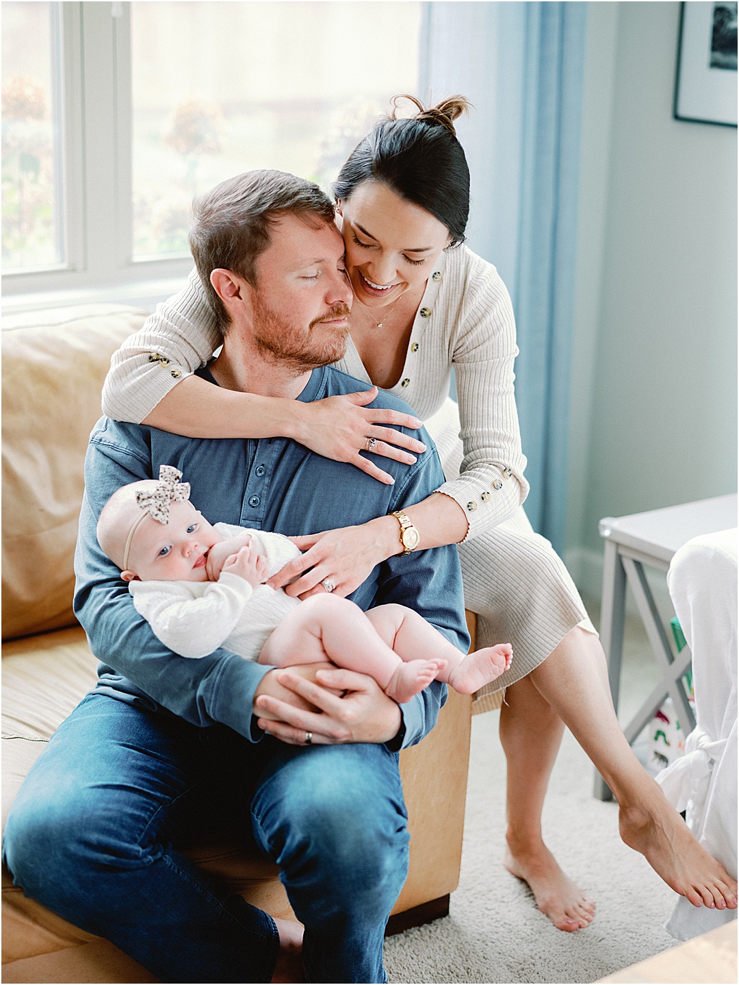 lifestyle photo of mom and dad holding baby