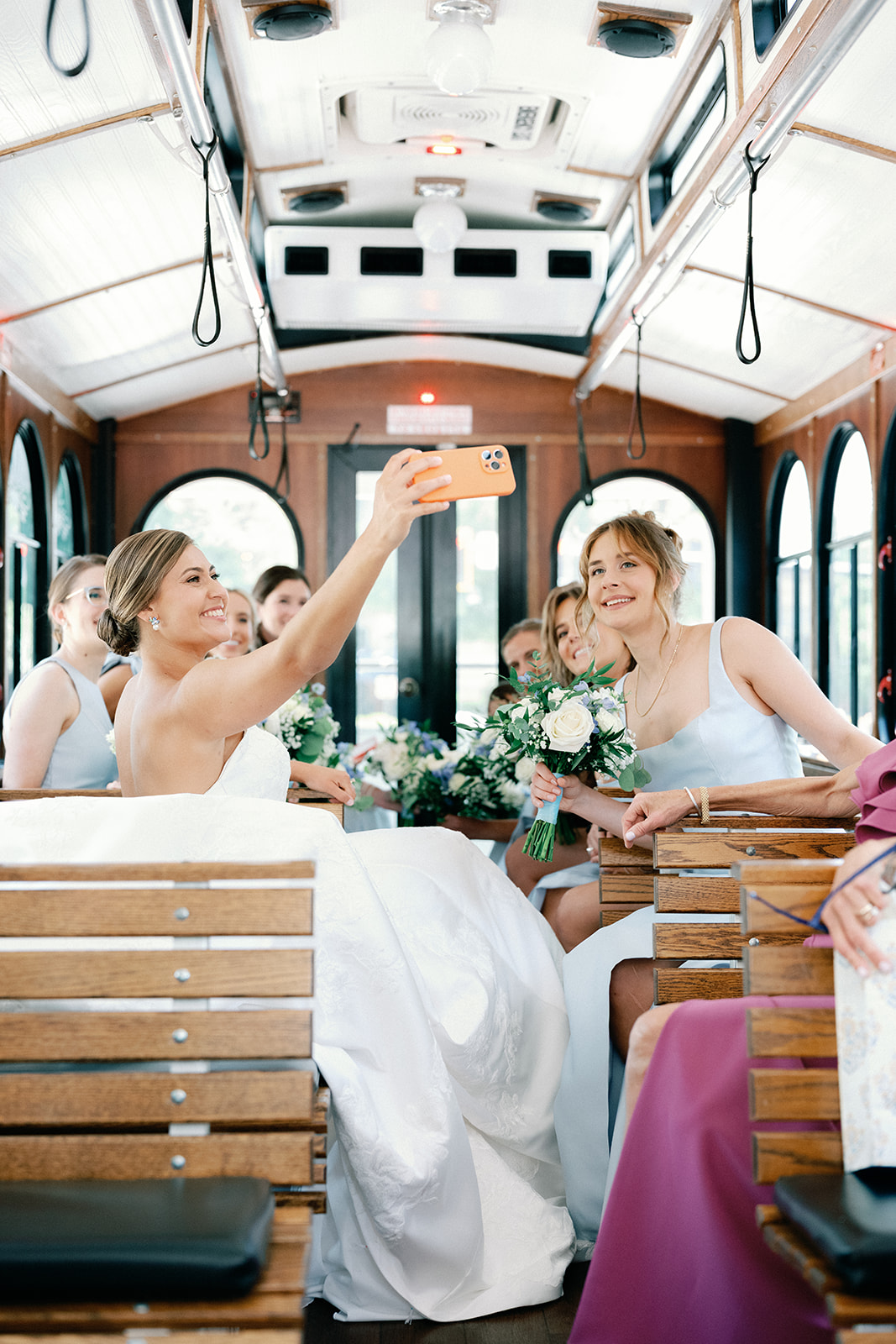 Bride and Bridesmaids Taking Selfie on Trolley on Way to Wedding